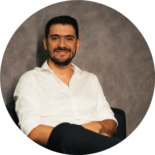 Retrato del Dr. Óscar Gómez, cirujano bariátrico en Medellín, sentado con camisa blanca y fondo neutro.